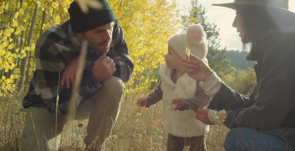 Parents playing with their toddler on the forest at morning