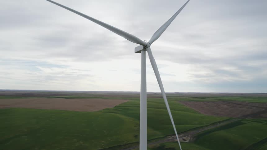Windmills are moving in a rural area at dusk