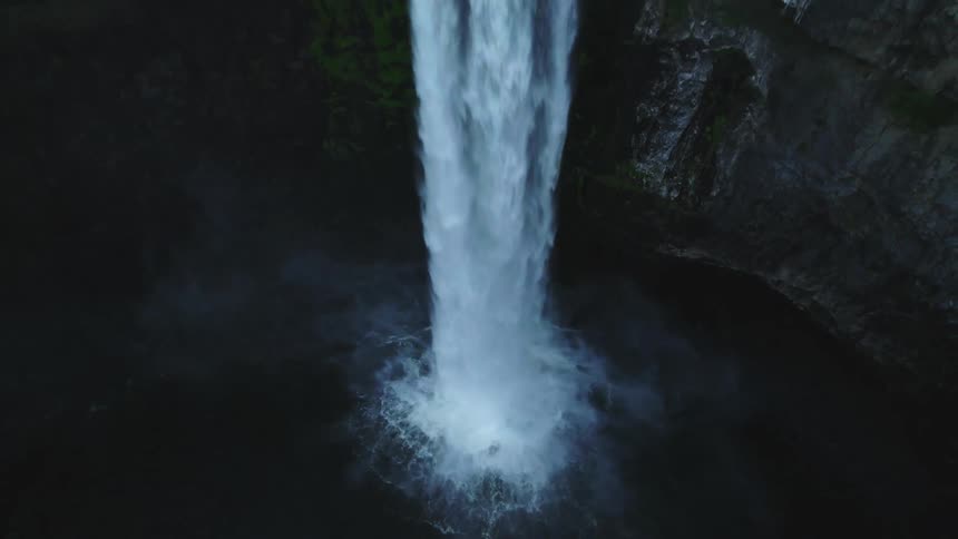 River water flows down a sheer cliff waterfall into a basin
