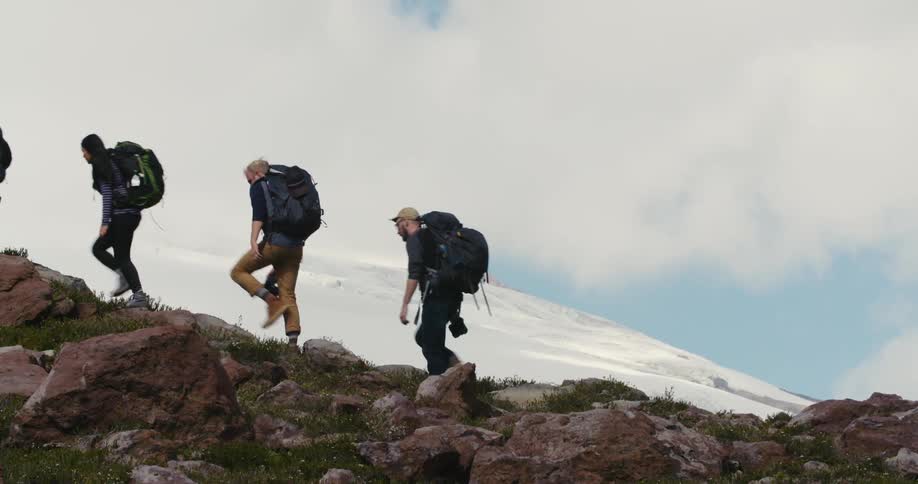 A group of friends hiking in snowy mountains on a cloudy day