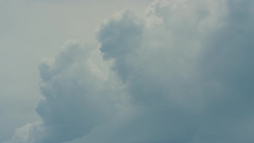 Big clouds flow across the blue sky