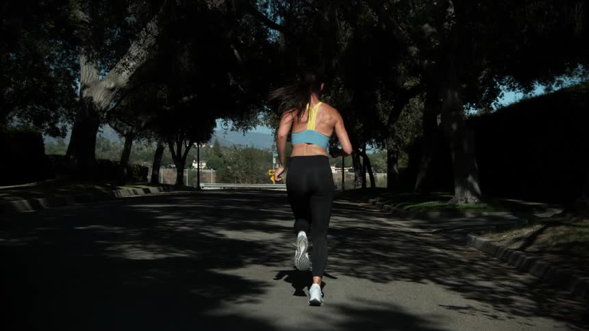 A woman is jogging outdoors in a neighborhood