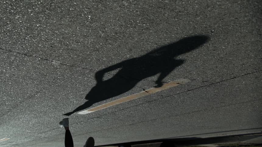 Shadow of woman jogging on a road outdoors in slow motion