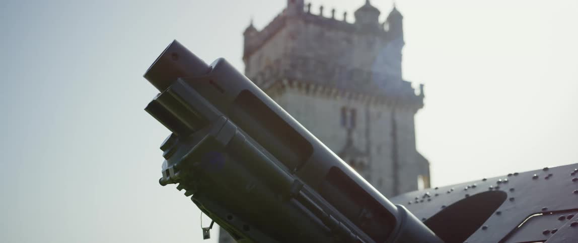 A large machine gun sticking out of the side of a tank