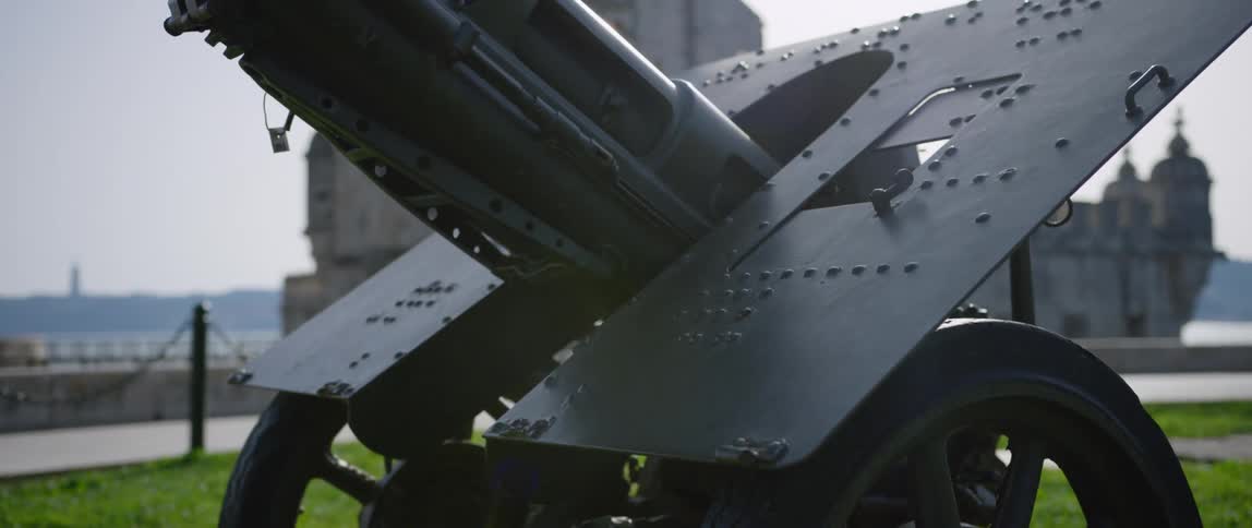 Artillery gun sits on grass with cathedral in the background