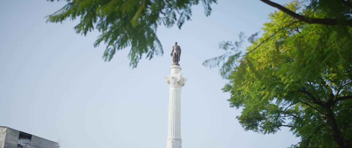 A statue is shown in a city during the spring time