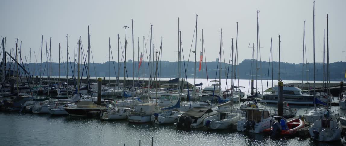 Sailboats and boats lie at anchor in the harbour