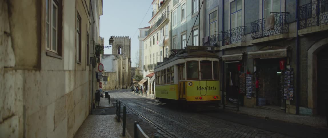 Passengers standing in the corner wait for the lisbon tram 28 at morning