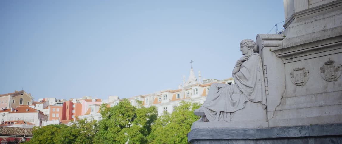 A bird sits on a statues head and then flies away