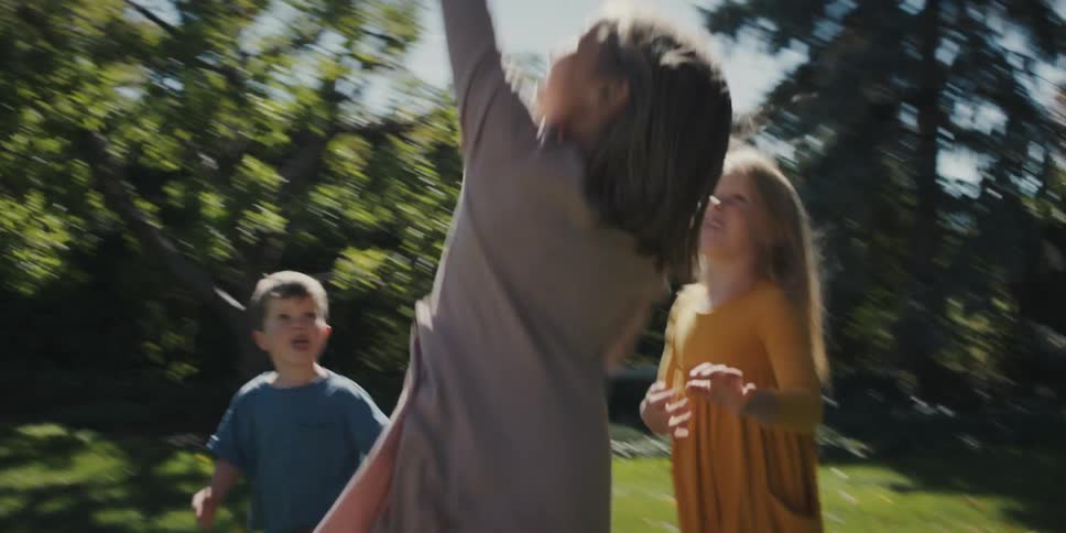 Children playing with a balloon on the lawn in the backyard