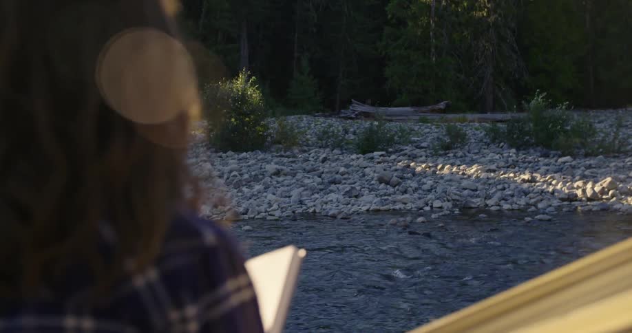 A woman is outdoors and reading a book during spring time
