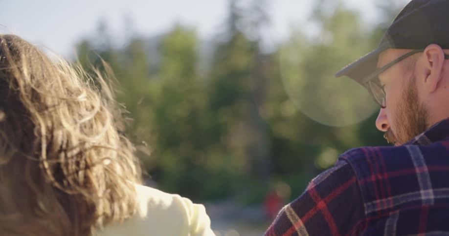 A man and woman talking outside on a sunny windy day