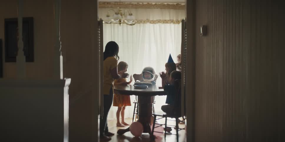 A family is celebrating a birthday in their kitchen