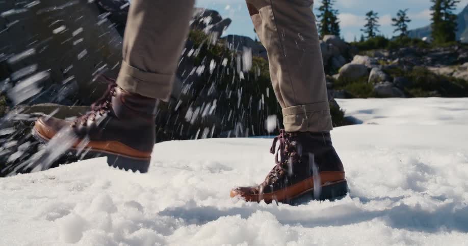 A person is kicking snow with their boots outdoors