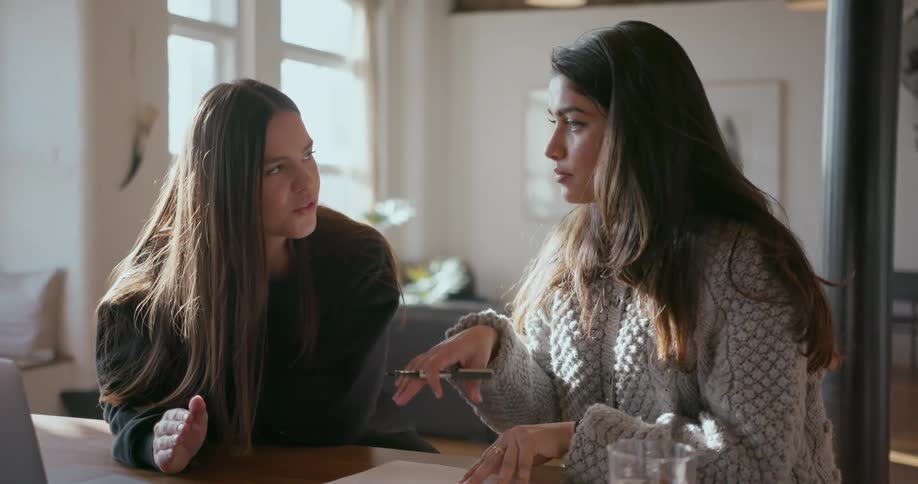 Two young women talking indoors