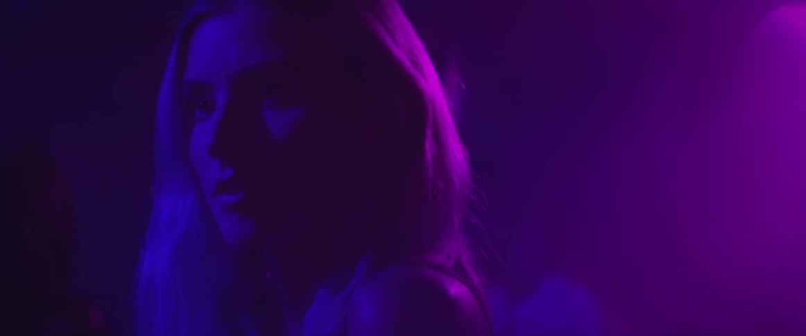 Blonde woman under purple and blue lighting