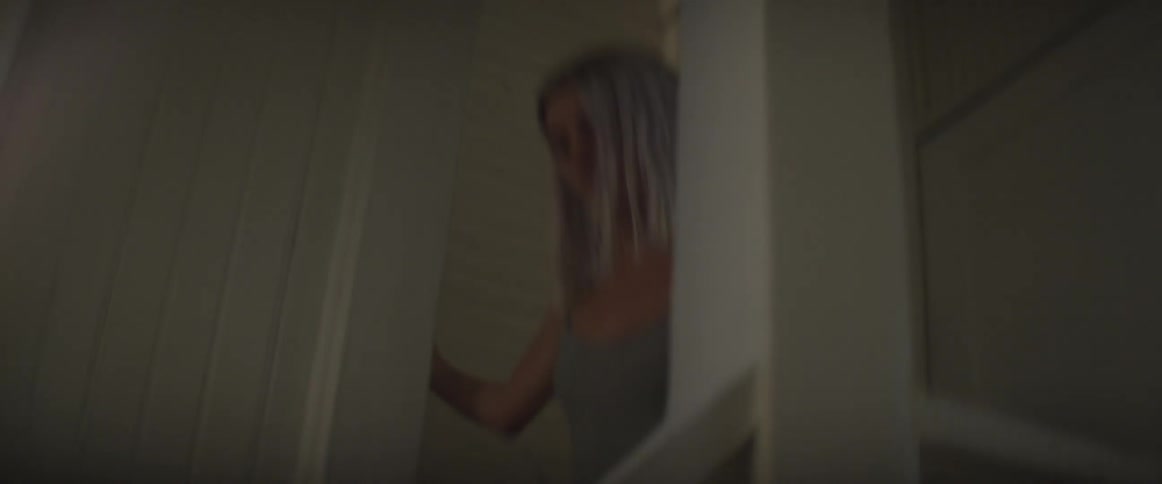 Blonde girl walking down stairs and through a doorway