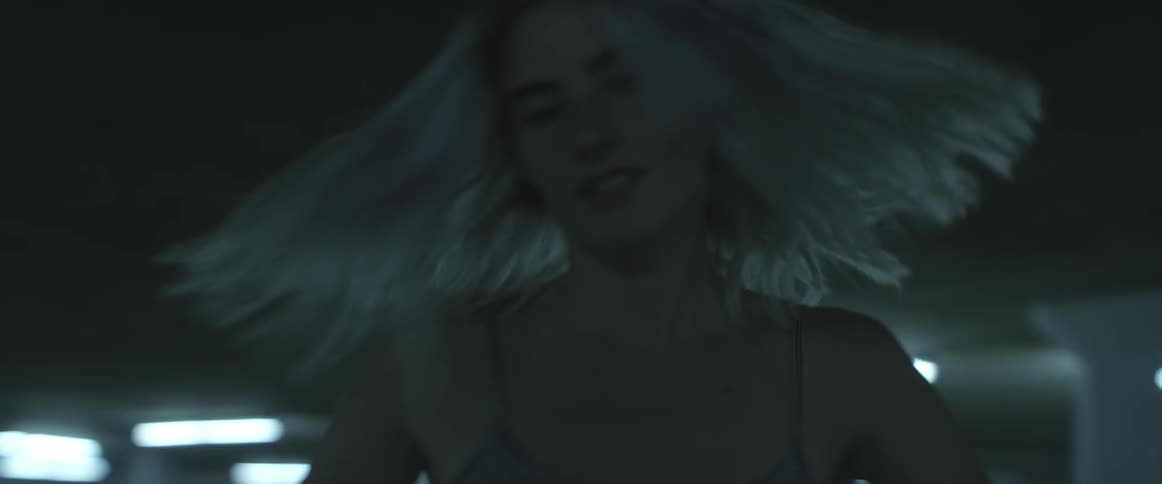 Woman spinning and dancing around in underground parking lot