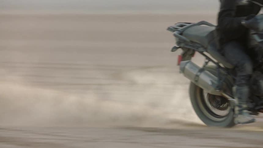 A motorcycle turns in the desert