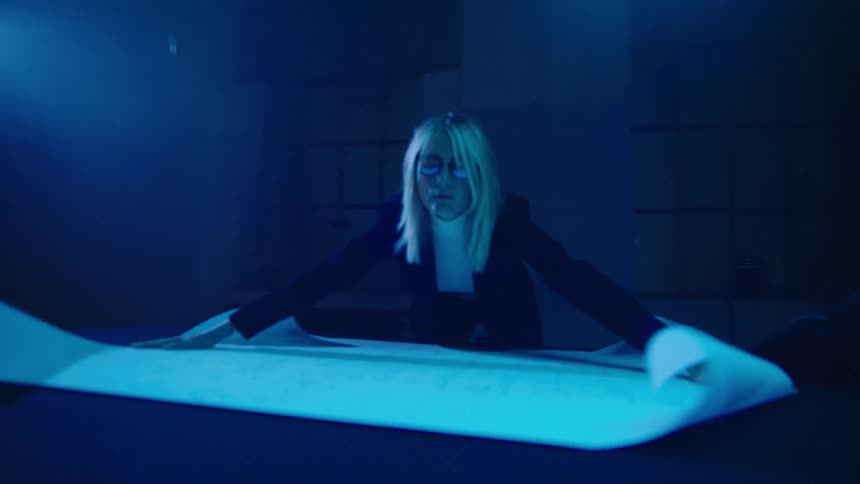 A woman is looking at a paper diagram indoors
