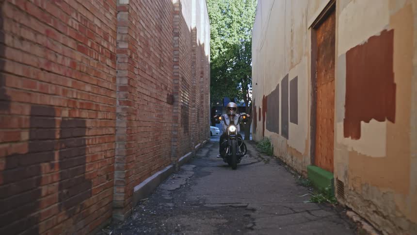 A motorcycle rides down the alley