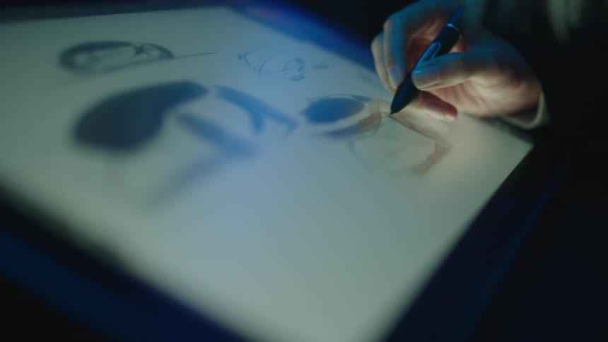 Persons hand draws on tablet