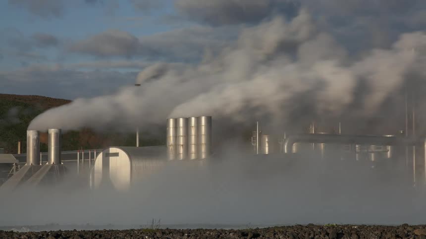 Heavy smoke rises from multiple chimneys at a factory