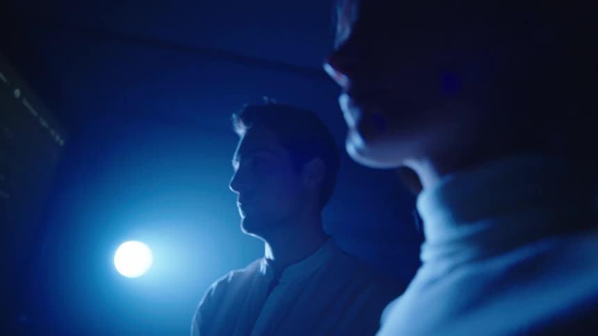 Two people look at a chart on the monitor