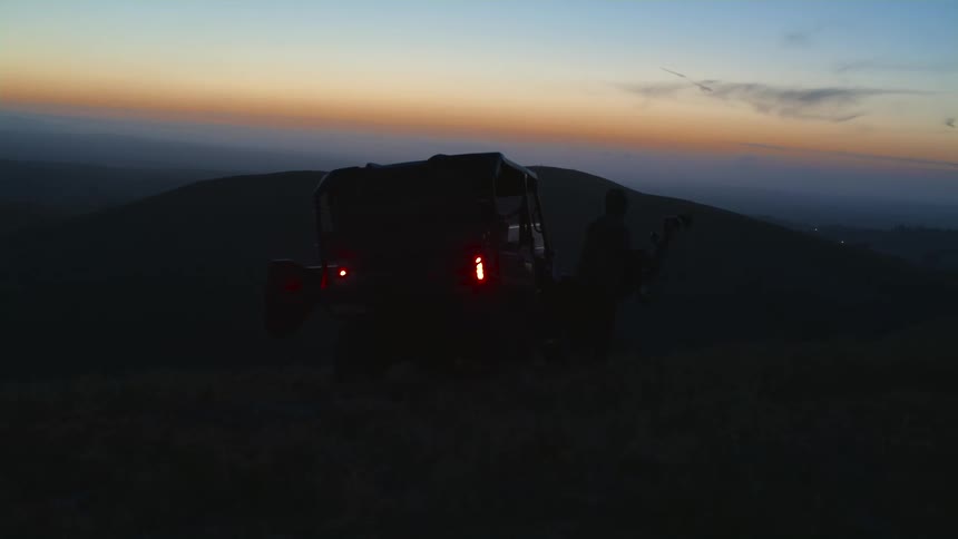 A man walks over to his vehicle at dusk