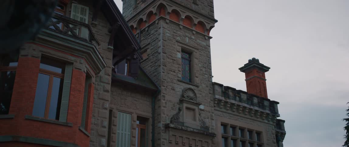 The stone building is near the tree
