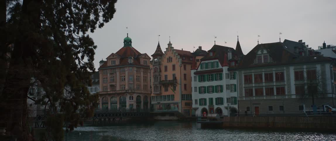 Buildings are near the coast of a body of water at dusk