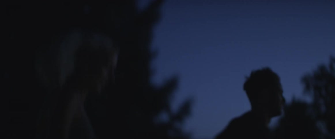 A man and woman run outside at night