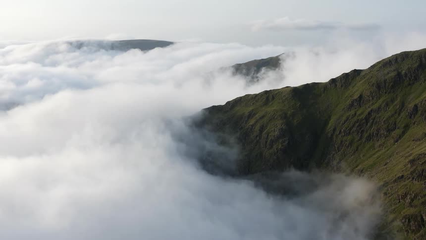 An aerial view of clouds moving across hills