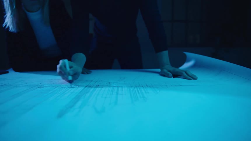 Two workers looking over designs and blueprints
