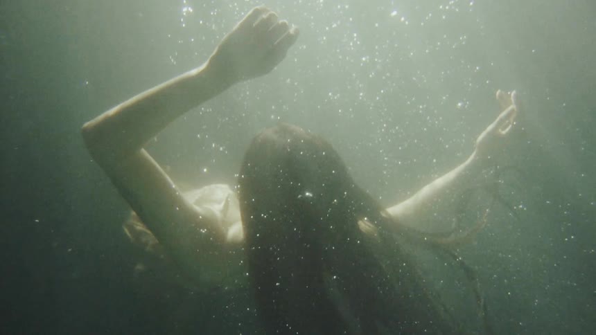 A woman is floating under the water