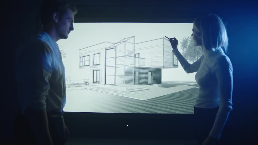 A man watches as an architect draws a line on an image of a building on a screen