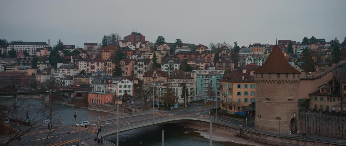 View of town houses tower and bridge over river on cloudy day