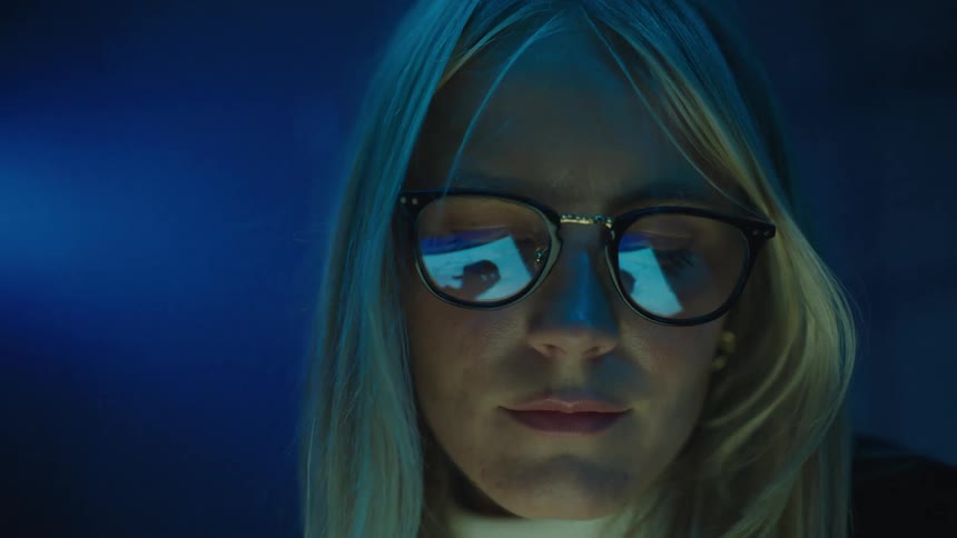 The reflection in a womans glasses show her drawing on a tablet computer