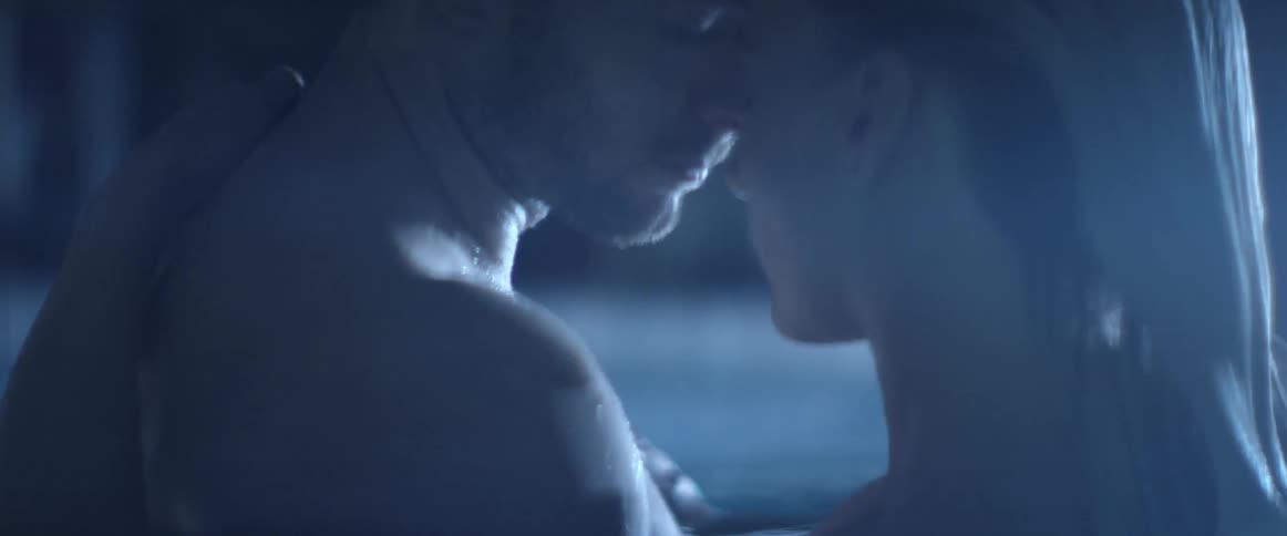 A man and women are hugging in a pool