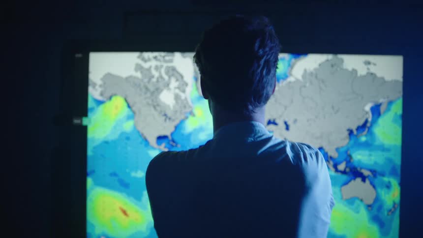 A man is looking at a map with weather displayed on it