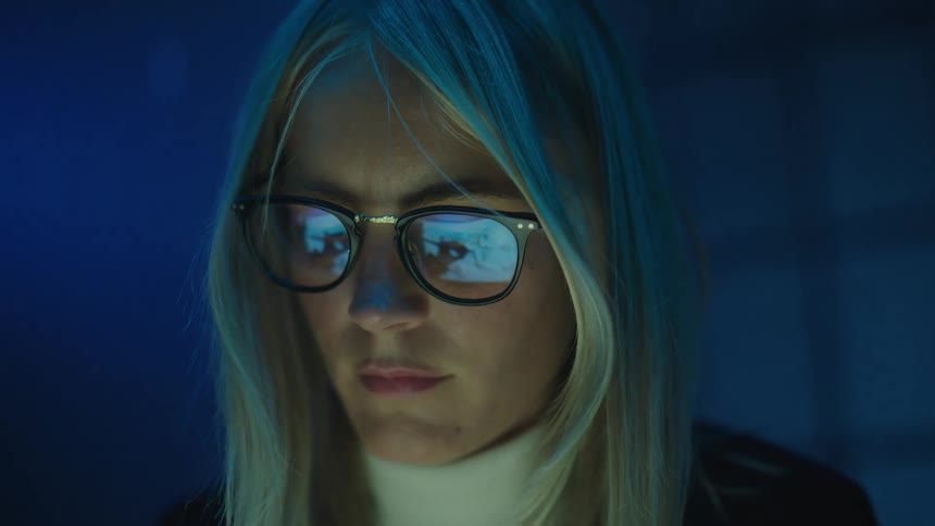 A woman is looking at something in the dark room