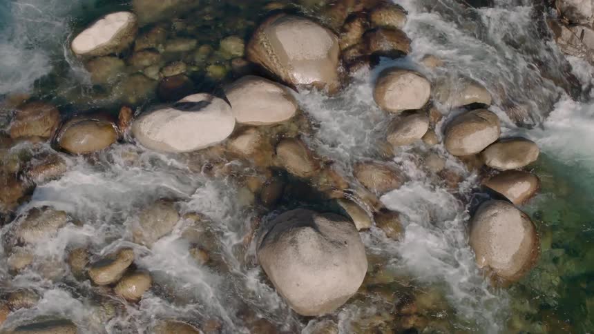Water flows over rocks in a shallow stream