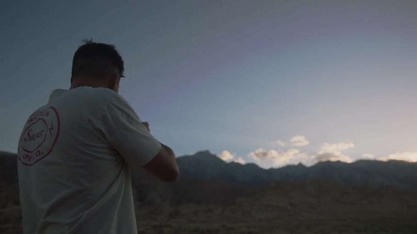 A photographer takes photos of a countryside landscape outdoors on a clear day