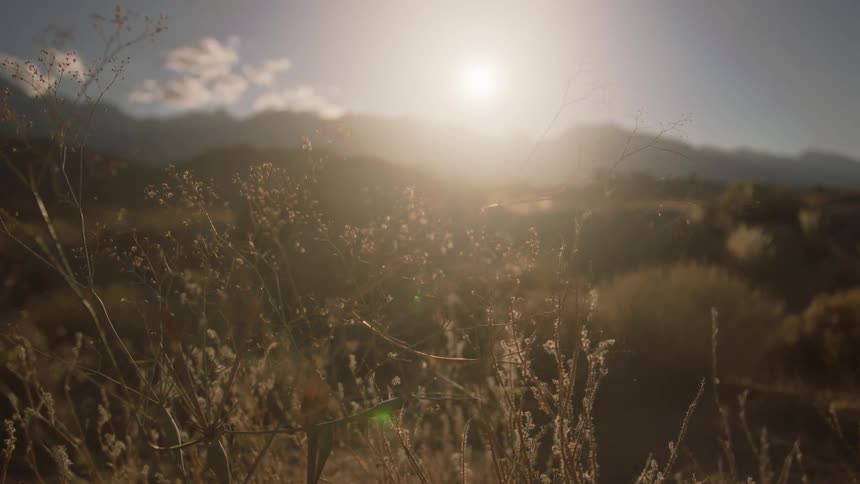 The sun shines over distant mountain and hills