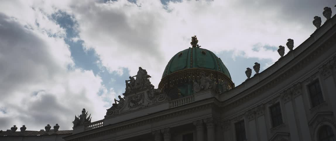 Building with a dome on top sits under a cloudy blue sky