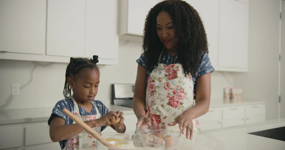 A woman and child cook in the kitchen