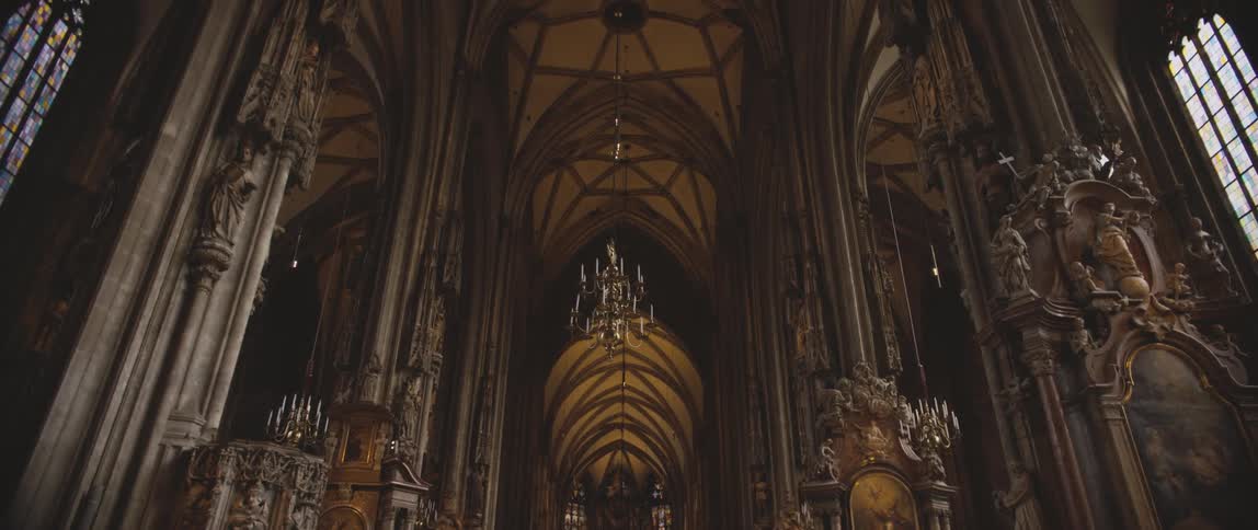 Ornate designs and statues and a chandelier inside a large church