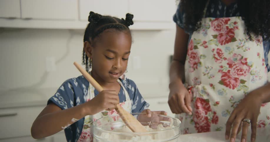 A mother and daughter are cooking in the kitchen