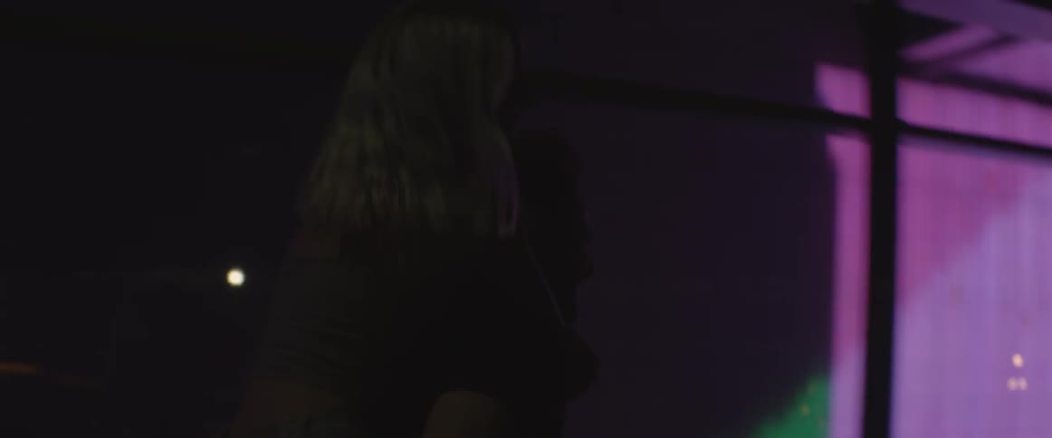 Man running a city street at night with a woman piggybacking
