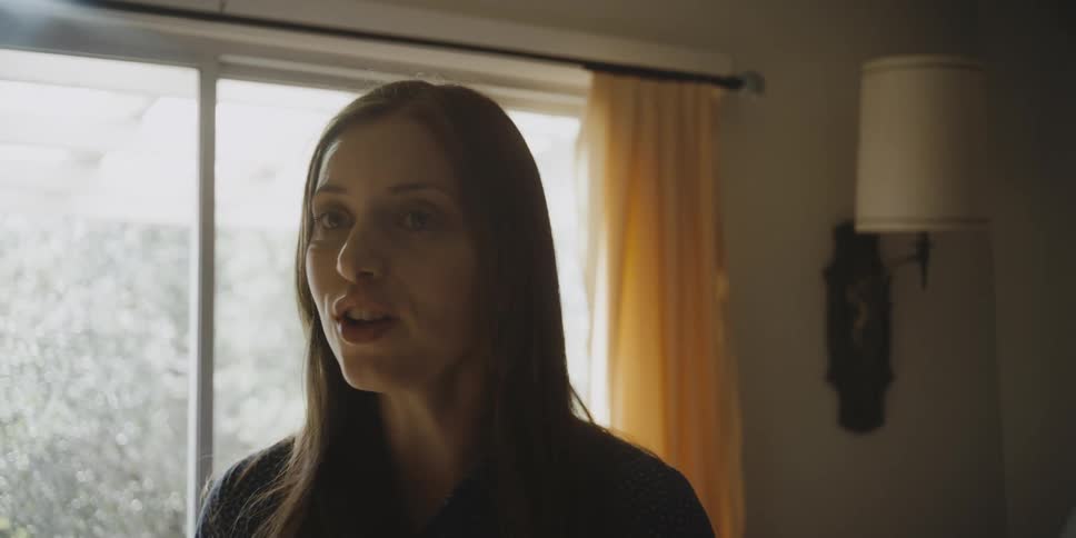 A woman standing in a home interior is arguing and shouting at someone